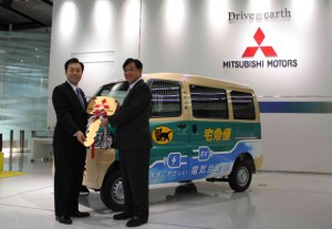 三菱自動車本社ショールームで、益子・三菱自動車社長（右）からキーを受け取るヤマト運輸の山内社長