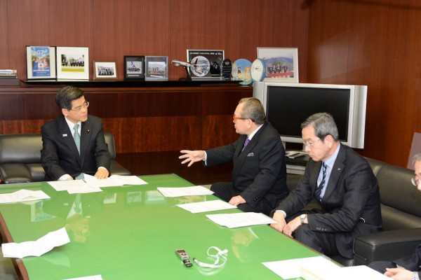 ▲石井国交相(左)に要望する坂本副会長(中央)
